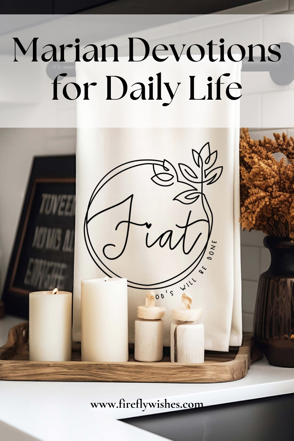 White cotton Fiat “God’s will be done” kitchen towel displayed in a kitchen with candles, wooden tray, and neutral decor accents.