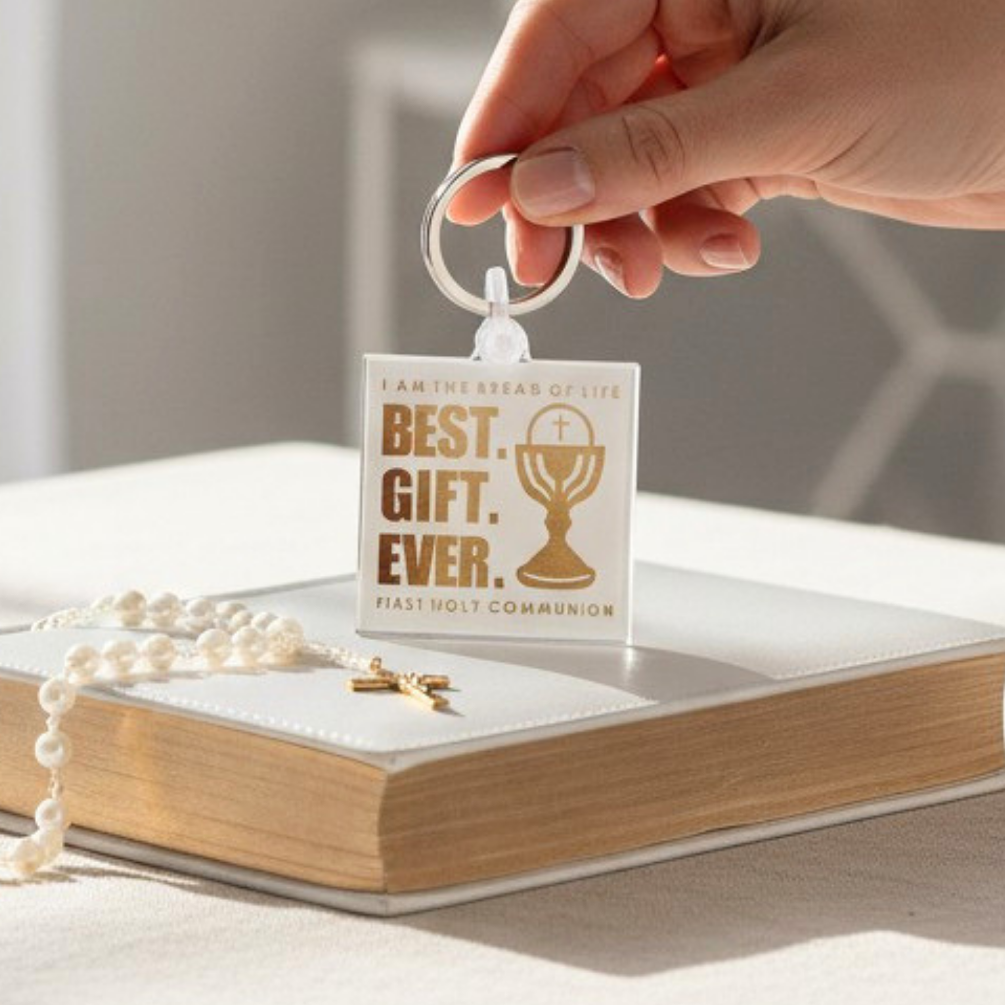 Keychain with 'Best Gift Ever' text on a book with a cross and rosary