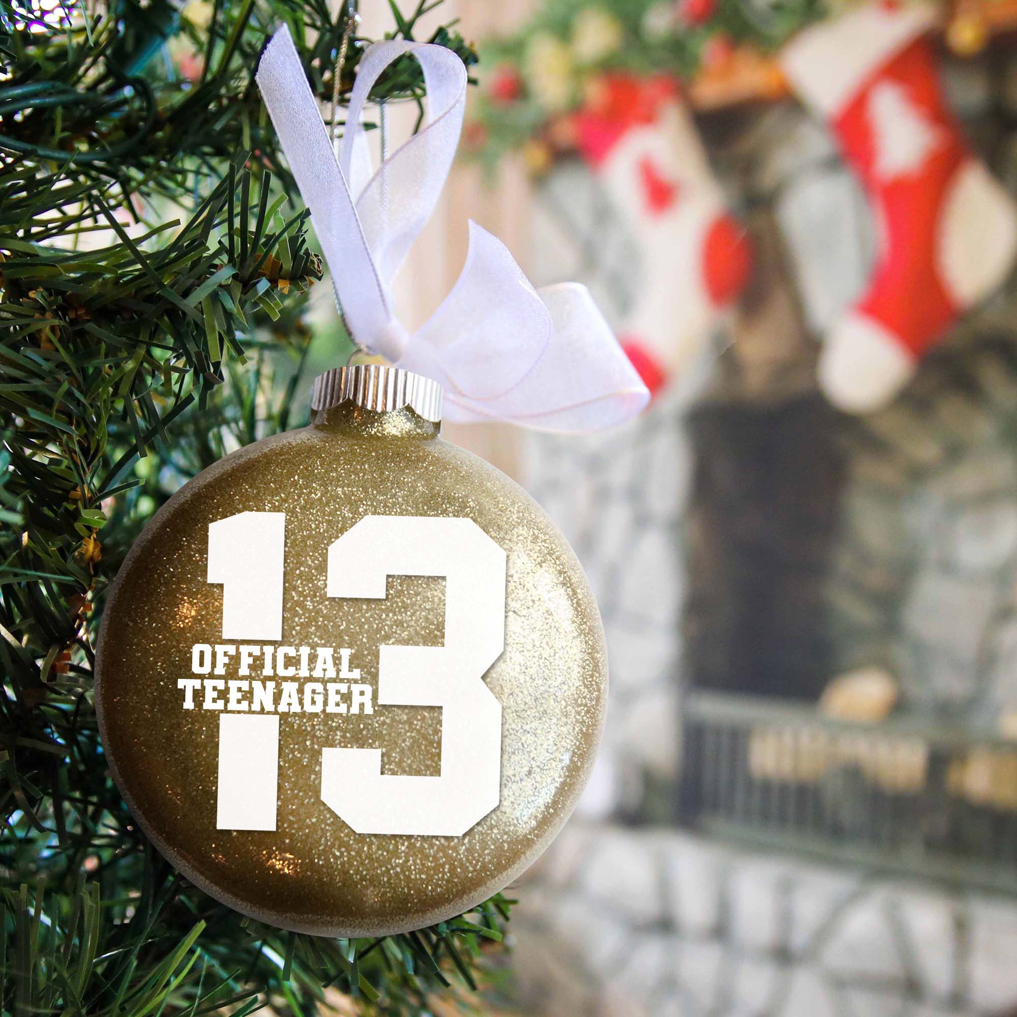 13 Official Teenager Birthday Ornament in gold glitter hanging in a Christmas tree 